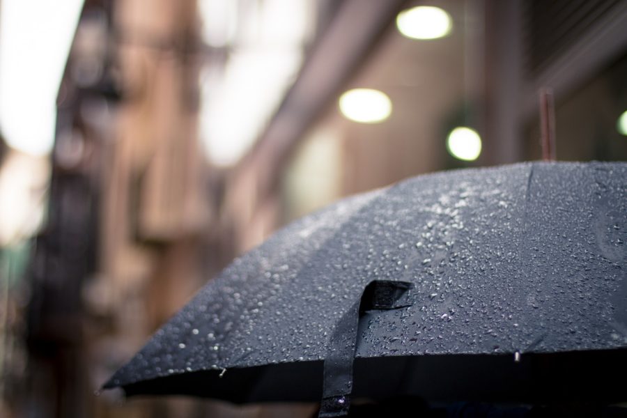 Regenschirm mit unscharfer Häuserfront im Hintergrund