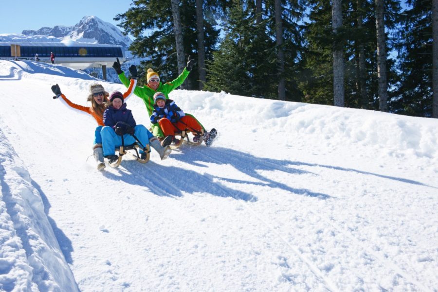 Familie fährt Rodelbahn hinunter